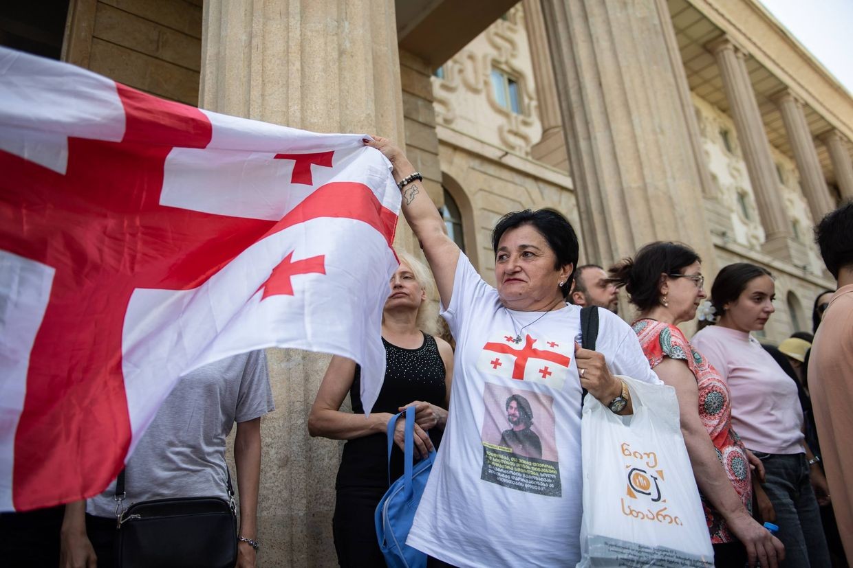 Marizi Kobakhidze, the mother of jailed protester Tornike Goshadze, waving a Georgian flag outside Tbilisi City Court after the verdict was announced. Photo: Mariam Nikuradze/OC Media.