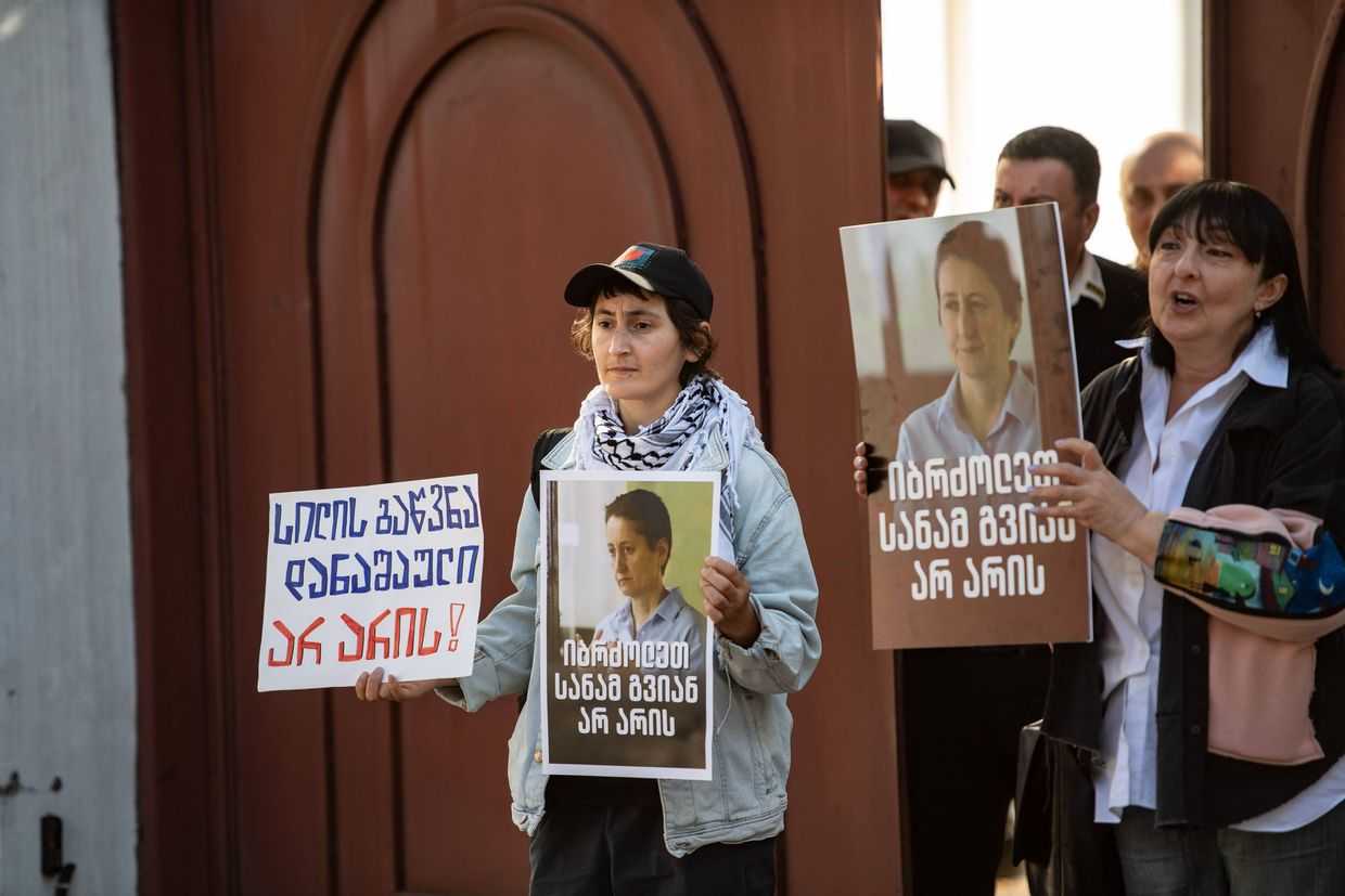 Protesters outside the Kutaisi Court of Appeals hold banners with Mzia's face and slogans of 'Slapping is not a crime' and 'Fight until it's too late'. Photo: Mariam Nikuradze/OC Media.