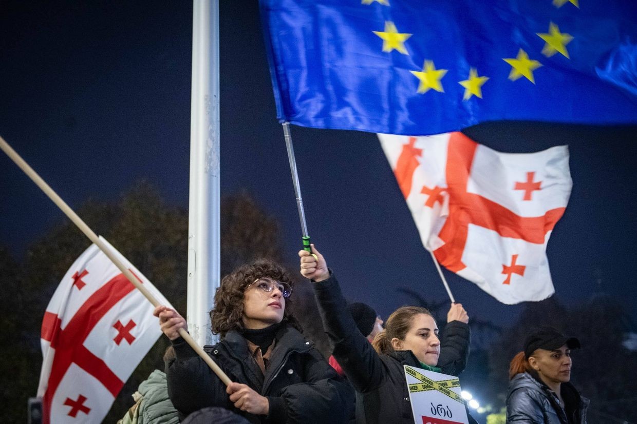 Protesters at the parliament holding Georgian and EU flags during the one-year anniversary of the daily demonstrations. Photo: Mariam Nikuradze/OC Media.