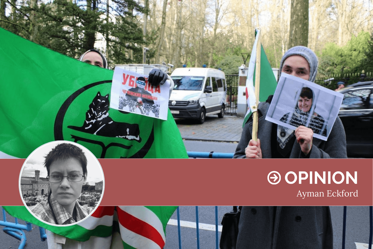 A demonstrator holds the flag of Ichkeria and an anti-Kadyrov poster, while her companion holds a poster of Zarema Musaeva. Photo: Loujaine Laamal.