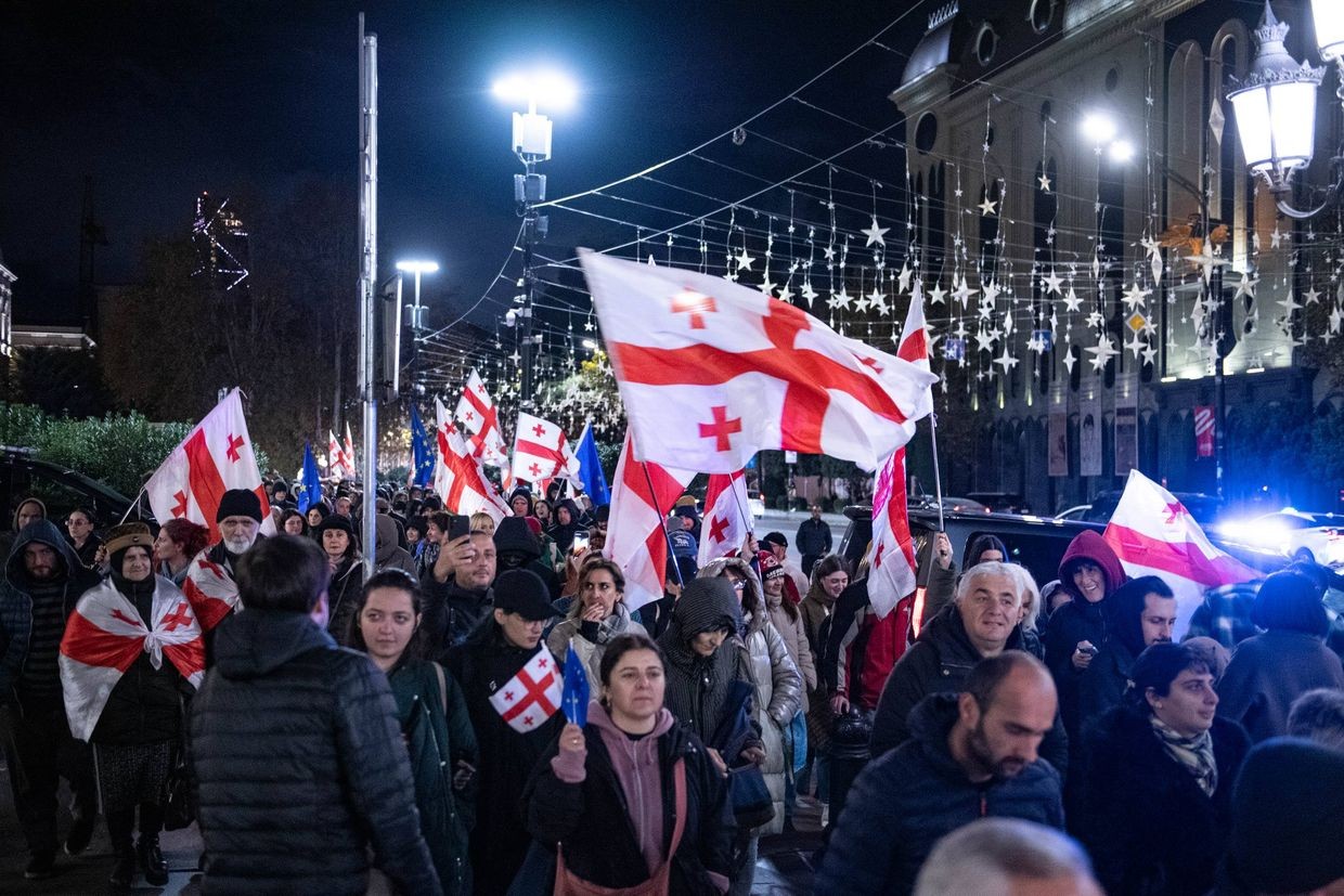 Tbilisi protesters march on the pavement in front of parliament. Photo: Mariam Nikuradze/OC Media.