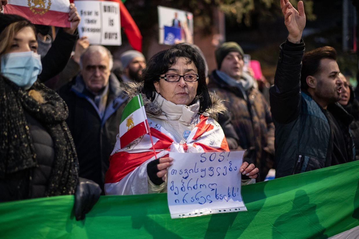 A Georgian protester standing at a solidarity rally in Tbilisi, holding a poster reading, ‘Freedom to the struggling people of Iran’. Photo: Mariam Nikuradze/OC Media. 