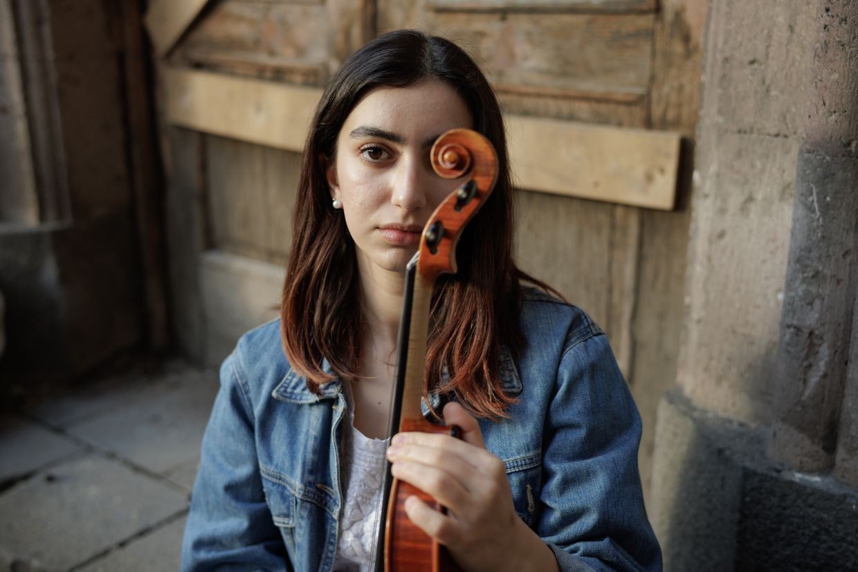 Reneta Dibaj holding her violin. Photo: Anthony Pizzoferrato/OC Media.