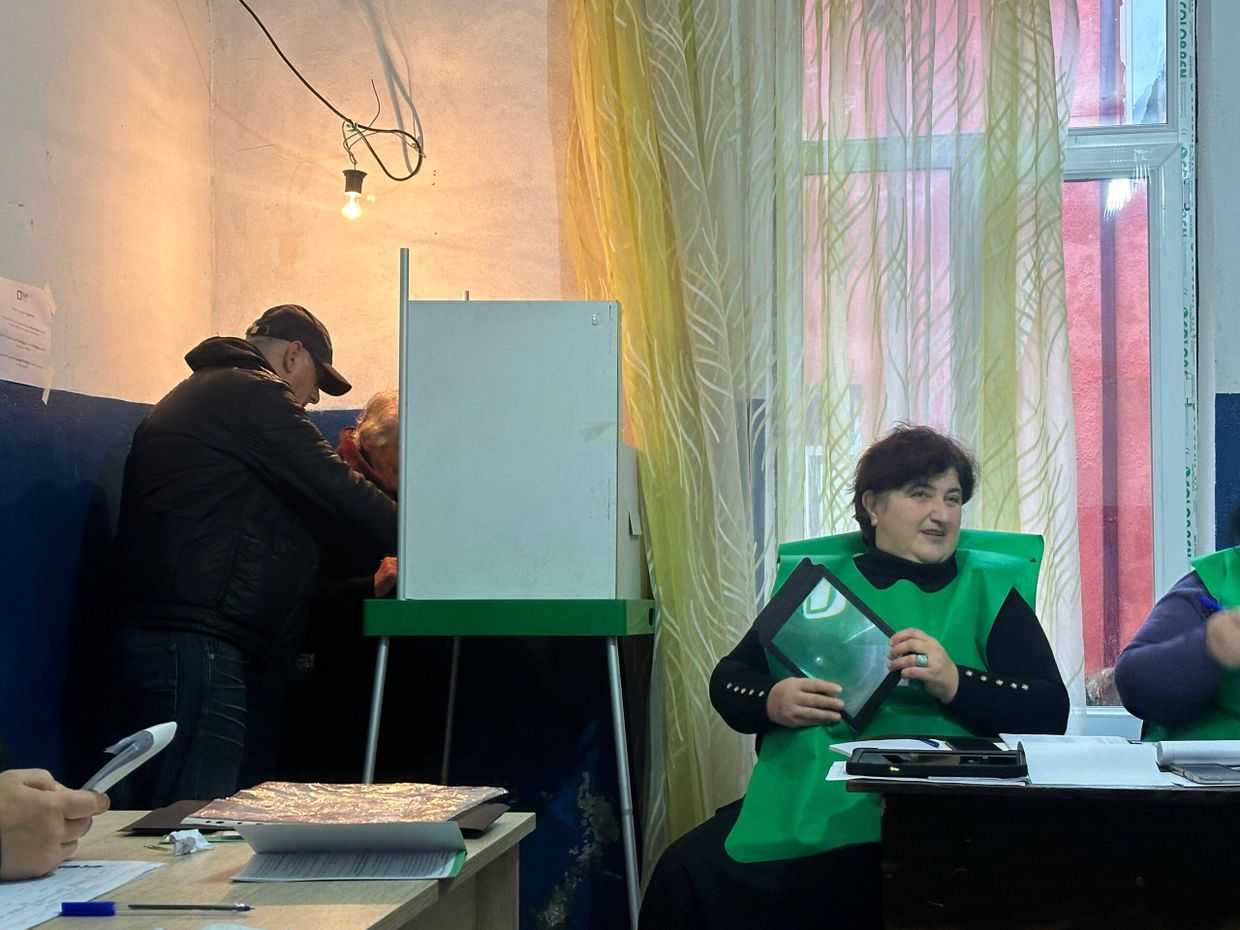 Temur Khukhunaishvili, the Deputy Chair of the Chokhatauri Municipal Council and a Georgian Dream member illegally ‘assists’ a voter on 26 October 2024. Photo: Kristina Kvatchantiradze/OC Media