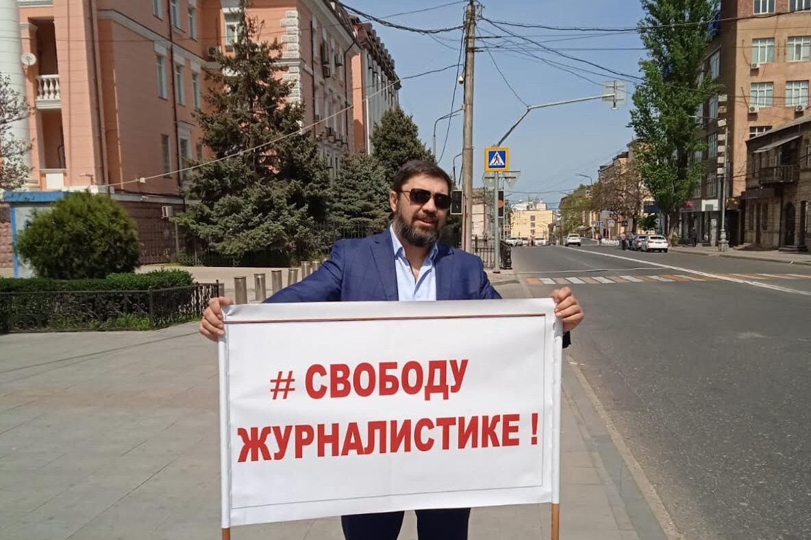 A man holds a single-person picket in Makhachkala, Daghestan on 2 May 2022. The sign reads: ‘Freedom for journalism’. Photo: OC Media.