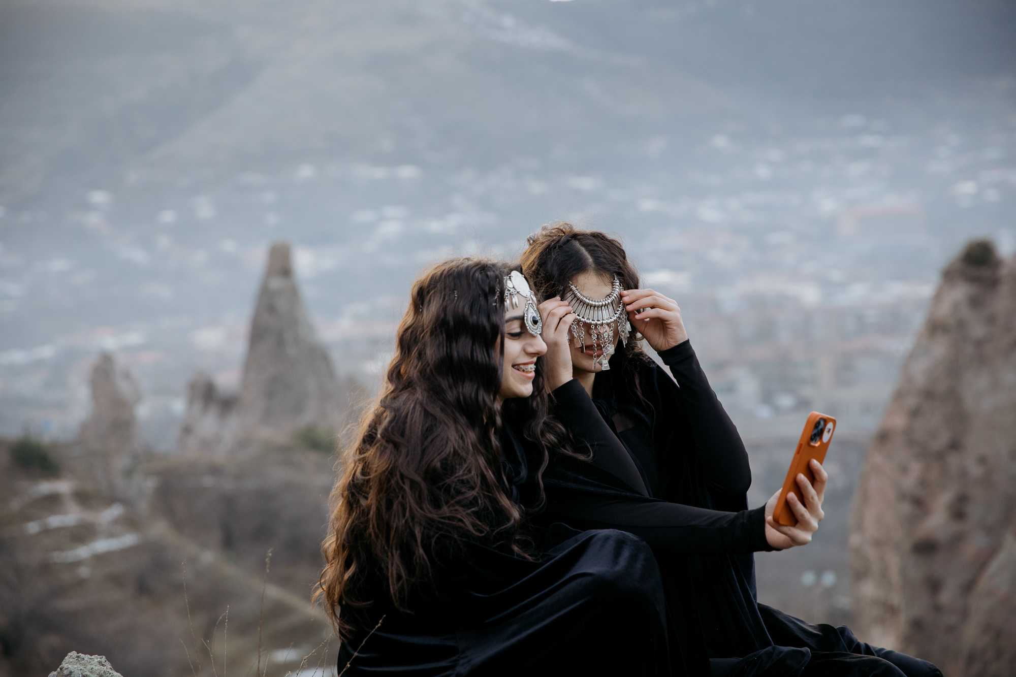 Samantha Boghosyan laughs while her friend and fellow dancer Anita Kagramanyan adjusts her costume during the filming of a dance video in the hills above Goris. Tom Videlo/OC Media.