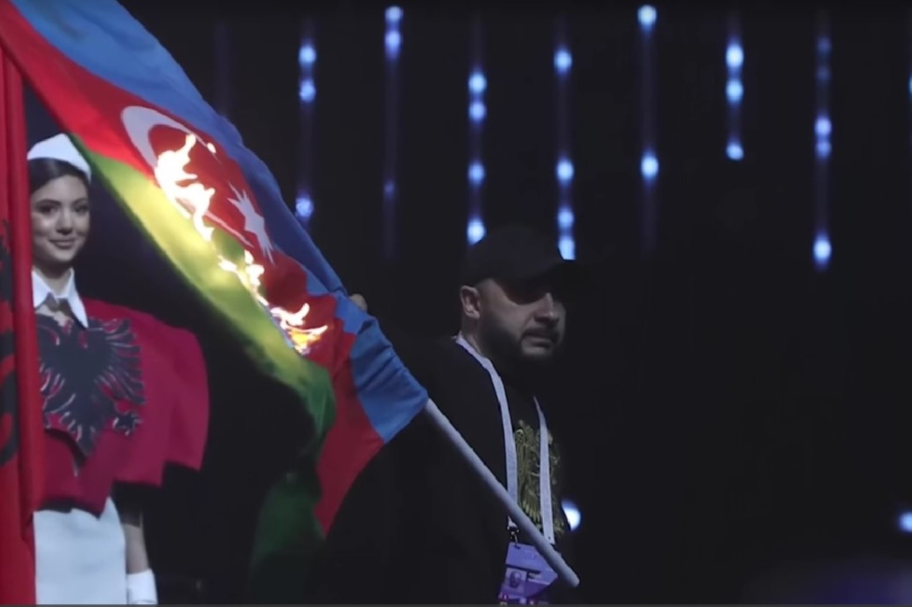 Designer Aram Nikolyan burning the Azerbaijani flag at the European Weightlifting Championship opening ceremony on Friday. Screenshot from video: RFE/RL