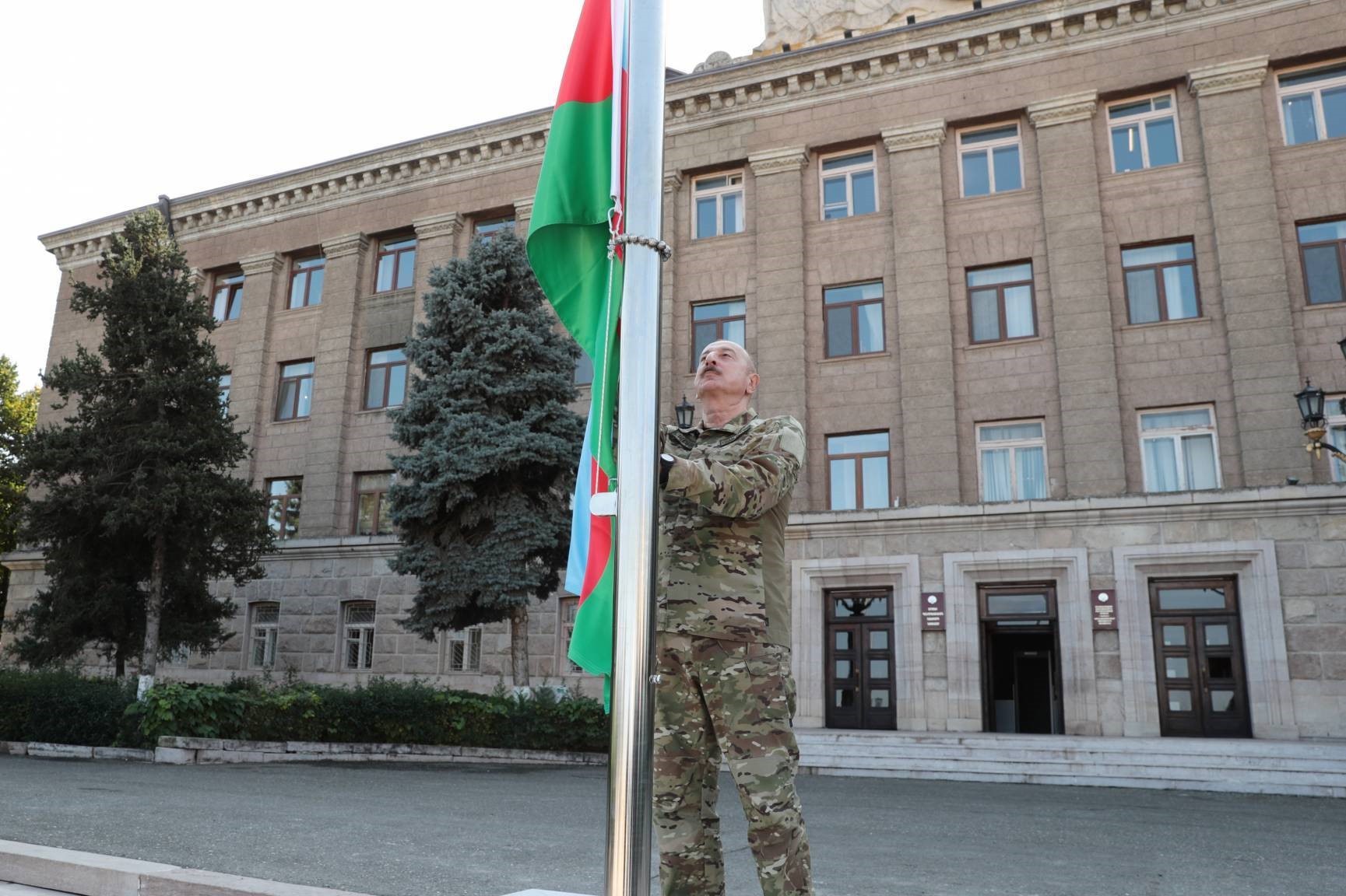 Azerbaijani President Ilham Aliyev raising the Azerbaijani flag in front of Nagorno-Karabakh’s former presidential administration on 15 October 2023. Image via the Presidential Administration.