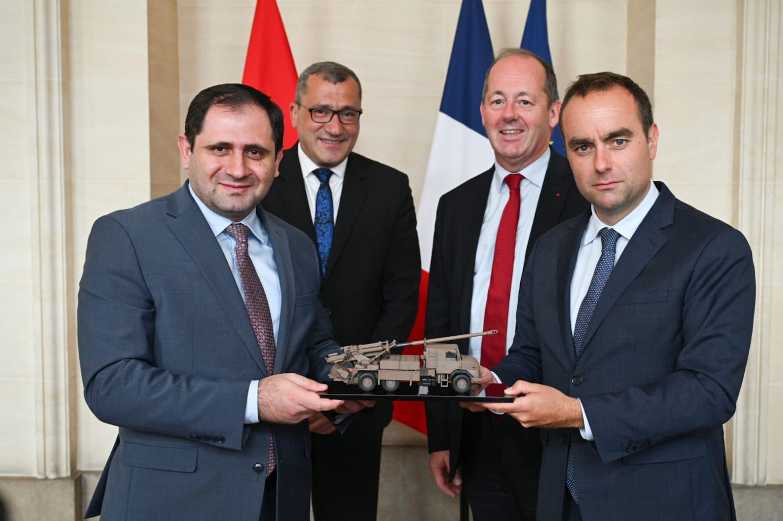 Armenian Defence Minister Suren Papikyan (left) and his French counterpart, Sébastien Lecornu, hold a model of the CAESAR artillery system.