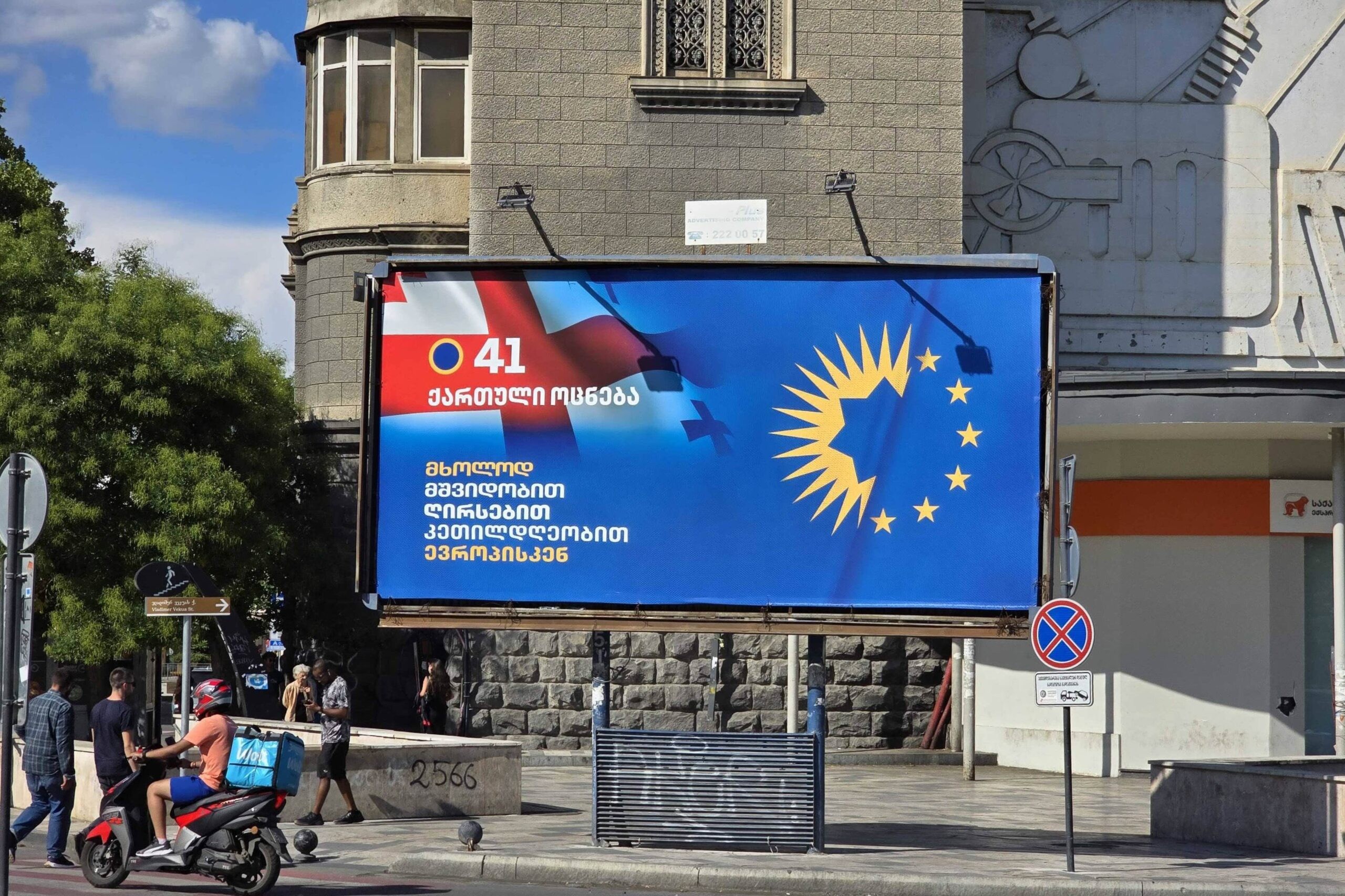 A Georgian Dream campaign banner in Tbilisi featuring the party’s logo merged with the EU’s flag, promising voters a path ‘to Europe only with peace, dignity, well-being’. Mariam Nikuradze/OC Media.