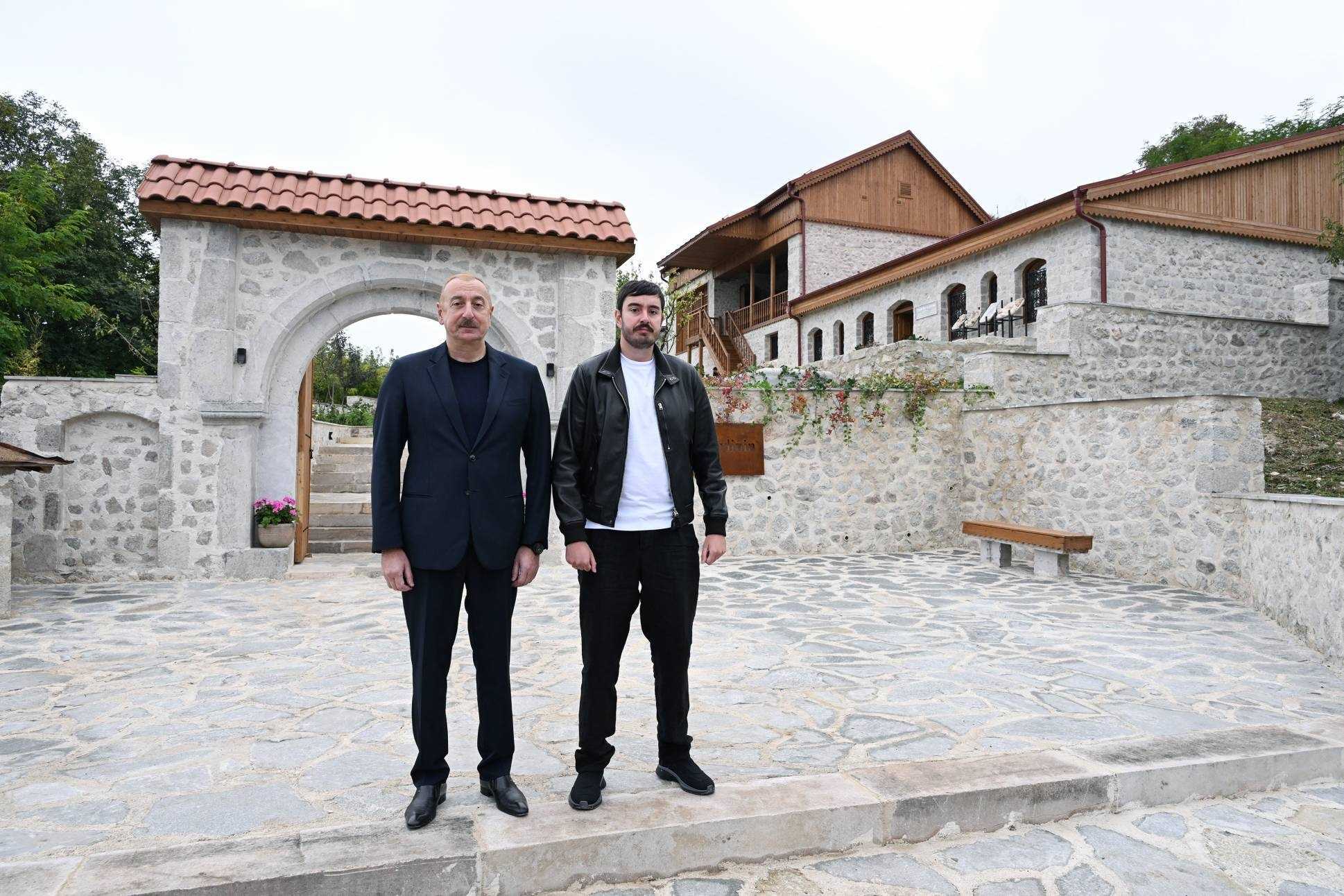 Azerbaijani President Ilham Aliyev standing with his son Heydar Aliyev Jr. in front of a house museum in Shusha. Image via President.az.