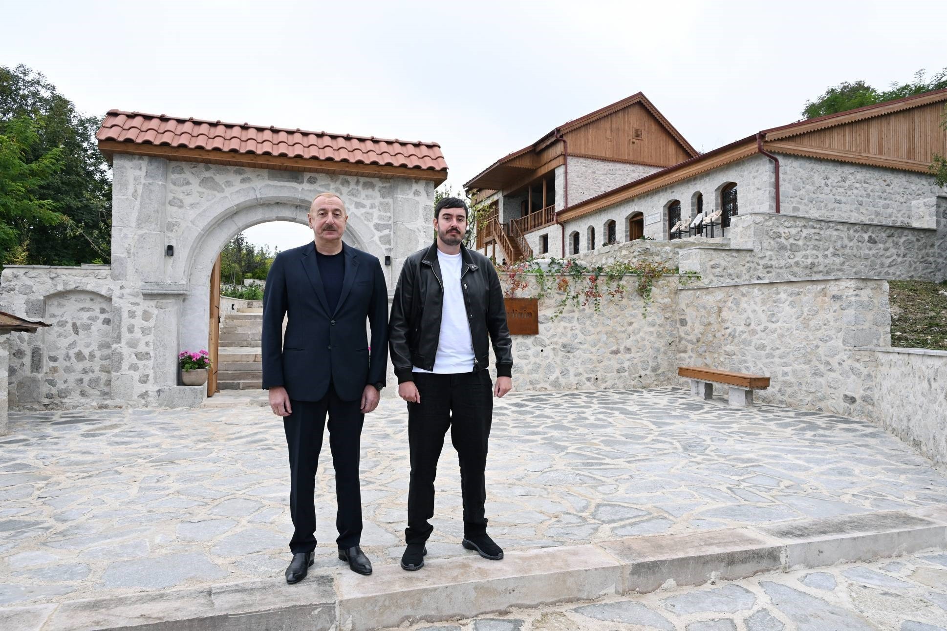 Azerbaijani President Ilham Aliyev standing with his son Heydar Aliyev Jr. in front of a house museum in Shusha. Image via President.az.