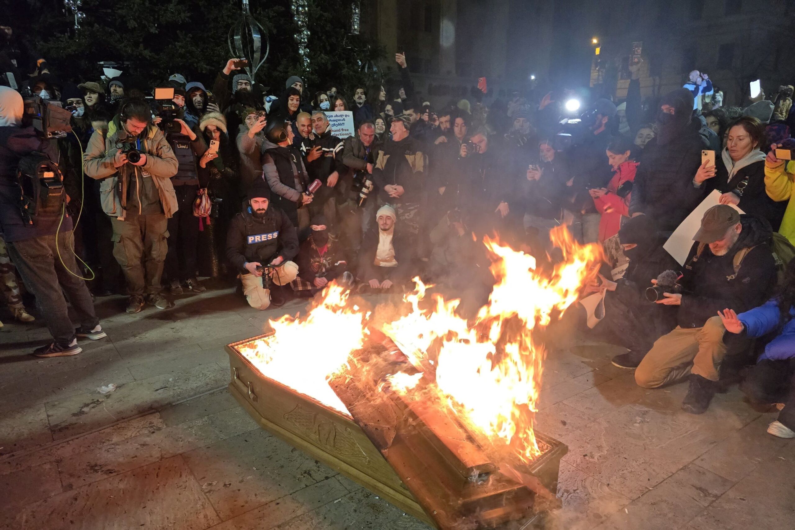 Protesters burn an effigy of Georgian Dream founder Bidzina Ivanishvili inside of a coffin in front of the Christmas Tree at the Georgian Parliament building in Tbilisi. Mariam Nikuradze/OC Media .