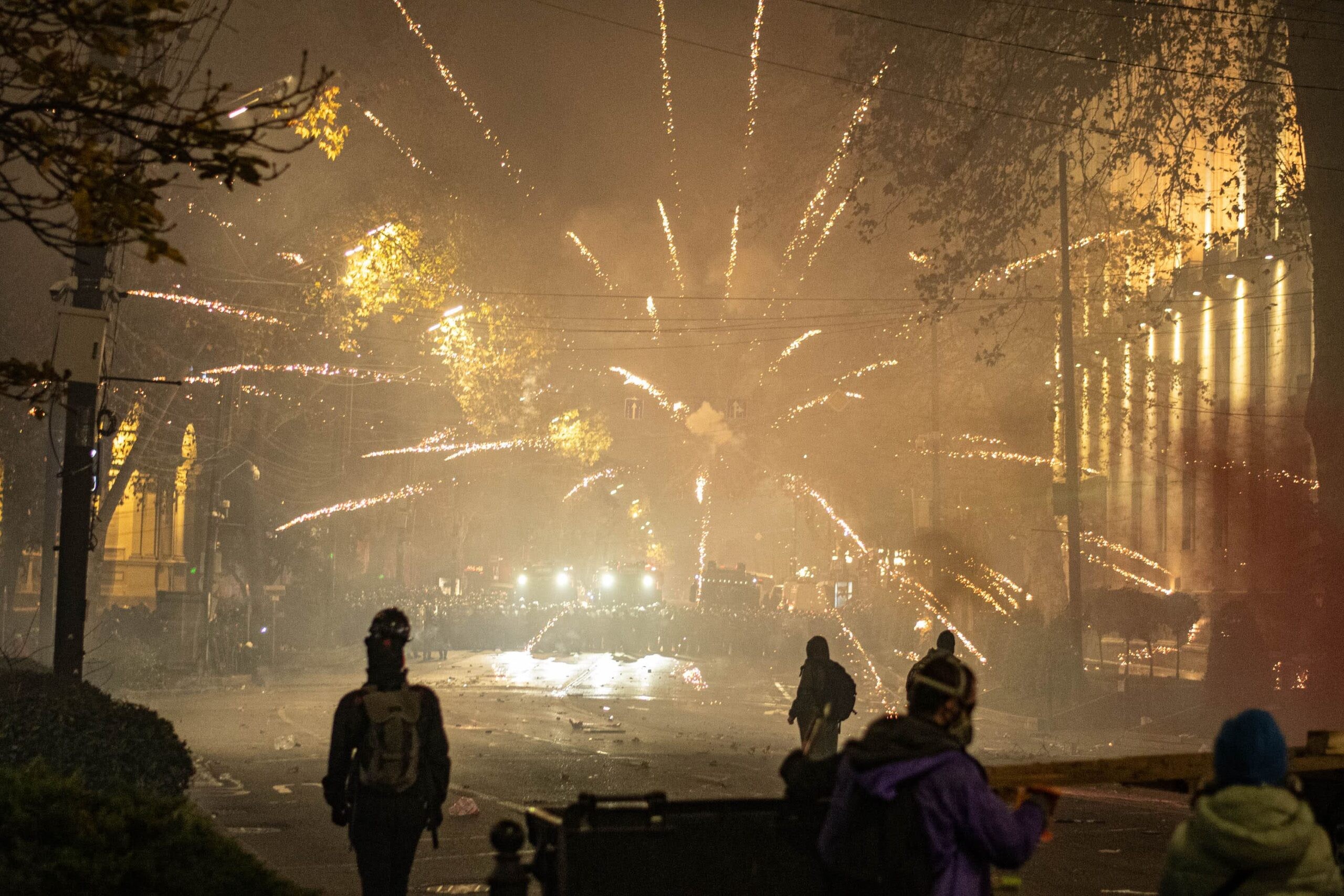 Fireworks burst over riot police gathered on Rustaveli Avenue in the early hours of 4 December. Mariam Nikuradze/OC Media.