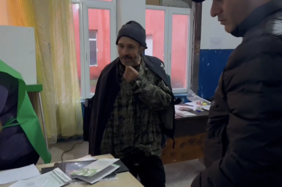 A State Security Service official identified by OC Media as Giorgi Mgeladze, brought in a person with a disability to vote. He did not have an ID on him. Photo: Kristina Kvatchantiradze/OC Media