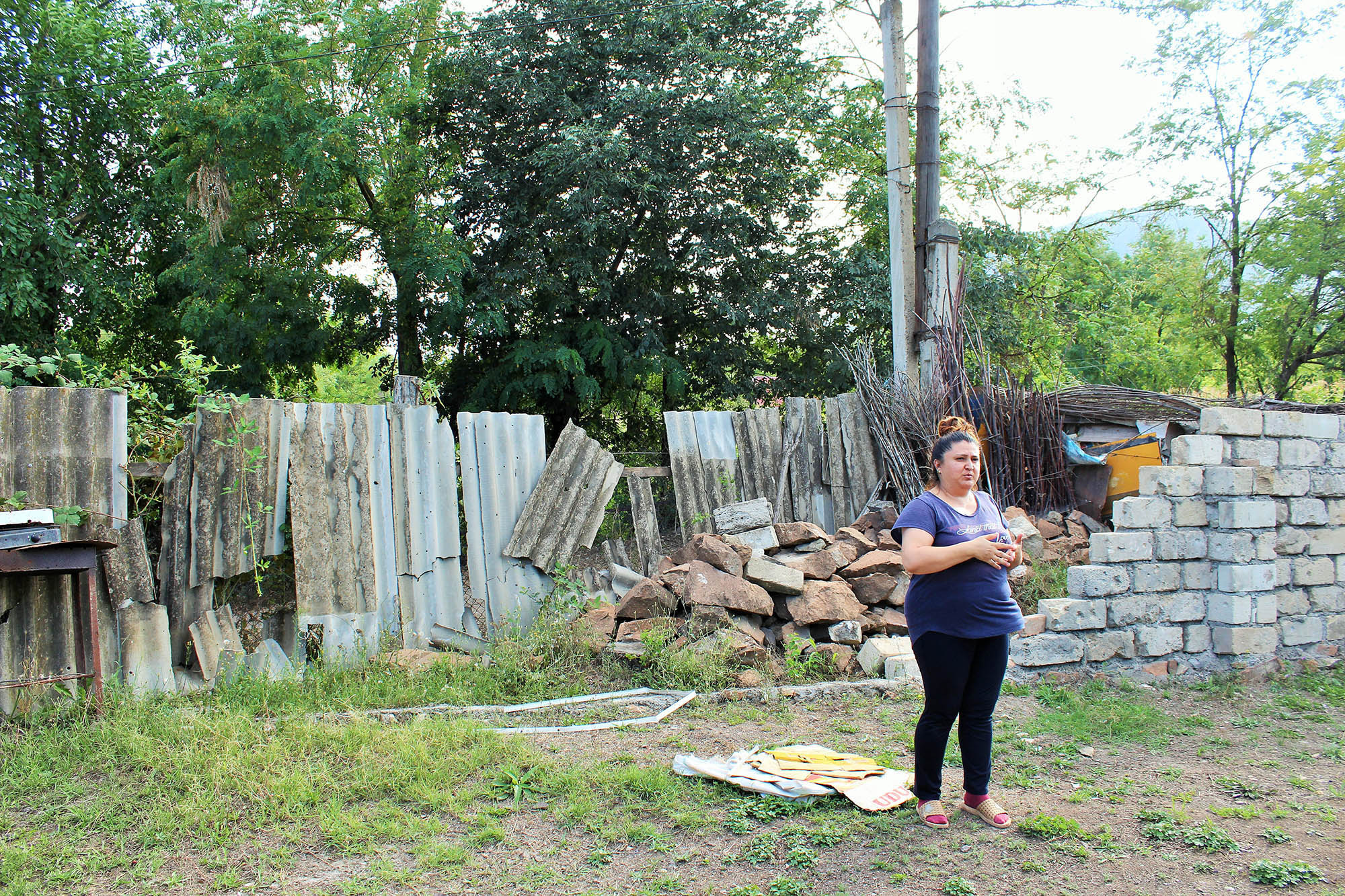 Дочь Азиза Азизова показывает, как пострадал дом её отца во время обострения конфликта. Фото: Сеймур Кязымов / OC Media