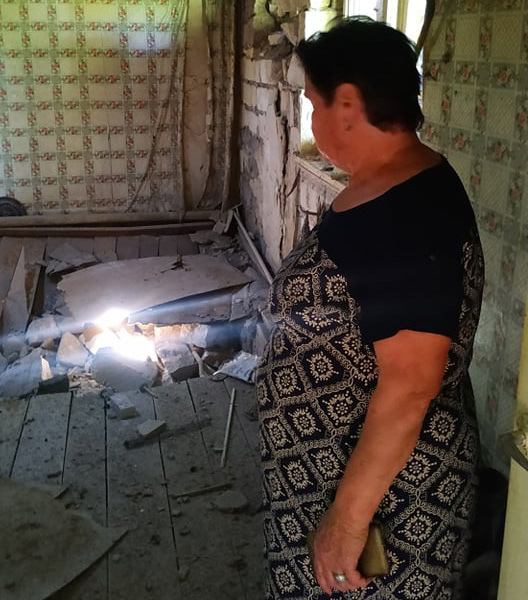 Лида Газарян показывает, как пострадал её дом в результате артиллерийского обстрела. Фото: Армине Аветисян / OC media